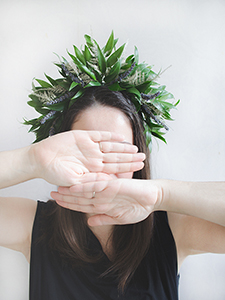 Andreea Teastyle wedding designer wearing leaf crown and covering face